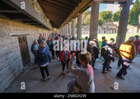 I gruppi di turisti, i turisti, affollano il quadriportico dei Teatri. Al Parco Archeologico di Pompei vicino a Napoli, Italia. Foto Stock