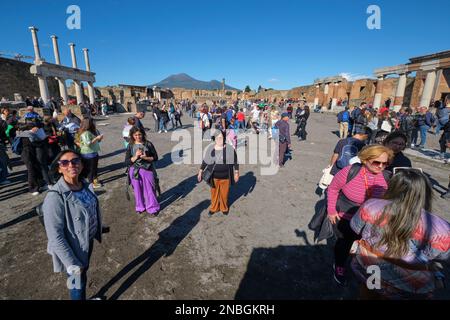 Gruppi di turisti, i visitatori imballano, affollano l'area del forum, in posa per le fotografie, selfie. Al Parco Archeologico di Pompei vicino a Napoli, Italia. Foto Stock