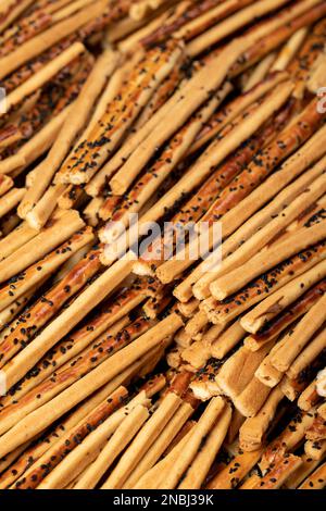 Il pane di pretzel si stacca con i semi di sesamo. Pretzel deliziosi in massa. primo piano Foto Stock