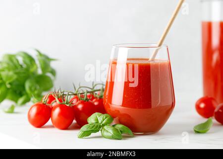 Succo di pomodoro in un bicchiere e pomodori freschi Foto Stock