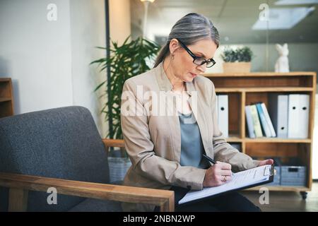Qualunque sia la tua sensazione, shell trova un modo per aiutarti. uno psicologo maturo che scrive note su una clipboard. Foto Stock