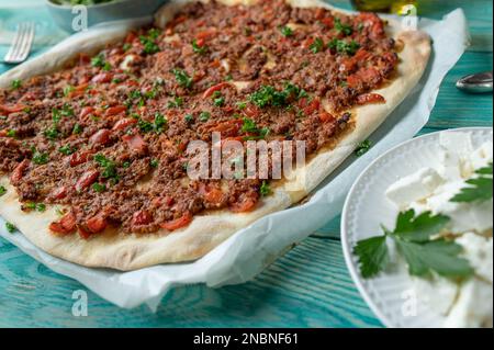 Pizza turca o lahmacun con carne macinata, pomodori, peperoni, aglio, cipolle ed erbe aromatiche Foto Stock