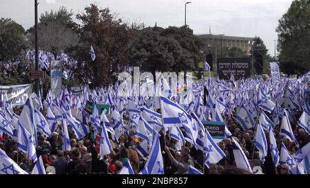 GERUSALEMME, ISRAELE - 13 FEBBRAIO: I manifestanti detengono bandiere israeliane durante una manifestazione di massa contro il nuovo piano del sistema giudiziario del governo israeliano che mira a indebolire la Corte Suprema del paese al di fuori del parlamento di Israele (Knesset) il 13 febbraio 2023, a Gerusalemme, Israele. Credit: Eddie Gerald/Alamy Live News Foto Stock