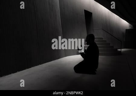 Foto islamica. Pregare l'uomo musulmano con le mani alzate in una moschea. Ramadan o kandil o laylat al-qadr Concept photo. Istanbul Turkiye - 11.12.2022 Foto Stock