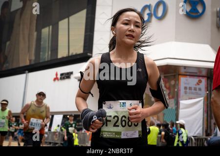Hong Kong, Cina. 12th Feb, 2023. Un corridore ha visto sudare mentre finisce il suo ultimo tratto della maratona. La maratona di Hong Kong Standard Chartered ritorna mentre oltre 30.000 corridori hanno sfidato il clima umido per competere in una giornata di nebbia. Il concorso annuale è stato sospeso per circa un anno a seguito della covida restrizione della città. Nonostante la città lentamente rilassando le sue misure di distanziamento sociale, i corridori devono indossare maschere prima e dopo la gara. Credit: SOPA Images Limited/Alamy Live News Foto Stock