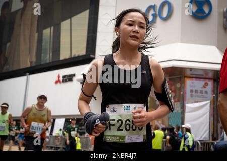 Hong Kong, Cina. 12th Feb, 2023. Un corridore ha visto sudare mentre finisce il suo ultimo tratto della maratona. La maratona di Hong Kong Standard Chartered ritorna mentre oltre 30.000 corridori hanno sfidato il clima umido per competere in una giornata di nebbia. Il concorso annuale è stato sospeso per circa un anno a seguito della covida restrizione della città. Nonostante la città lentamente rilassando le sue misure di distanziamento sociale, i corridori devono indossare maschere prima e dopo la gara. (Foto di Ashley Chan/SOPA Images/Sipa USA) Credit: Sipa USA/Alamy Live News Foto Stock