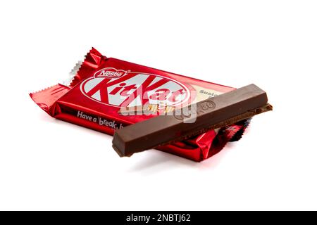 Londra. UK-02.12.2023. Un pacchetto di KitKat con una barra di cioccolato rotta sulla parte superiore. Isolato su sfondo bianco. Foto Stock