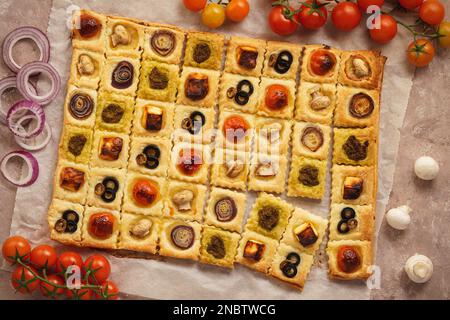 Mini torte di pasta sfoglia con pomodori ciliegini, funghi, olive, feta e cipolla. Foto Stock