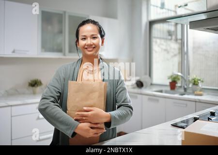 Ritratto di donna felice che tiene il pacchetto con il cibo consegnato Foto Stock