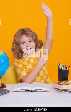 Bambino della scuola che alza le mani, disposto a rispondere alla domanda. Studente di scuola che impara in classe, studia la lingua inglese a scuola. Scuola elementare Foto Stock