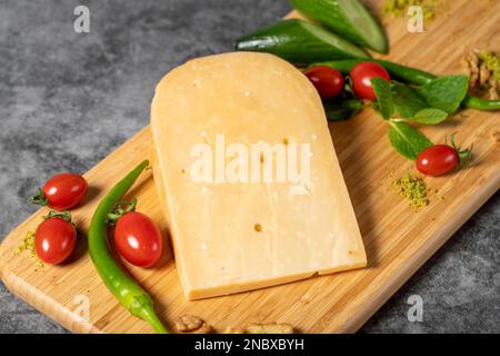 Formaggio Gouda. Pezzo di formaggio gouda su tagliere di legno. Raccolta di formaggi. Formaggio stagionato a base di latte vaccino nei Paesi Bassi Foto Stock