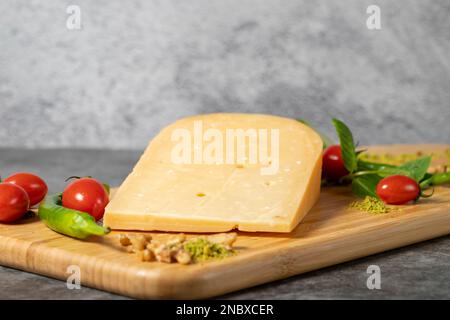 Formaggio Gouda. Pezzo di formaggio gouda su tagliere di legno. Raccolta di formaggi. Formaggio stagionato a base di latte vaccino nei Paesi Bassi Foto Stock