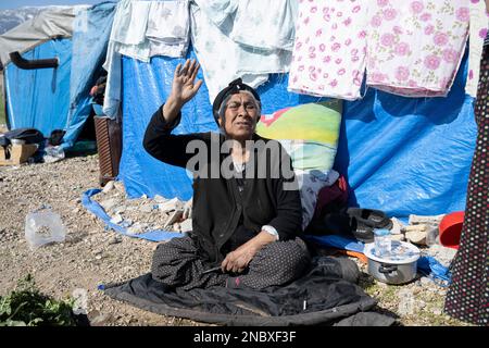 KIRIKHAN, Turchia. 14th Feb, 2023. Una donna siede fuori dal suo rifugio di tenda di fortuna sul lato della strada. Più di una settimana dopo le devastanti scosse in Turchia e Siria, c’è poca speranza di trovare altri sopravvissuti tra le macerie. Credit: Boris Roessler/dpa/Alamy Live News Foto Stock