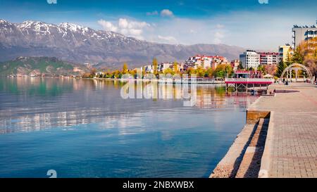 Molo vuoto nella città di Pogradec con neve catena montuosa sullo sfondo. Pittoresca scena primaverile del lago di Ohrid. Luminosa vista mattutina dell'Albania, Europa. T Foto Stock