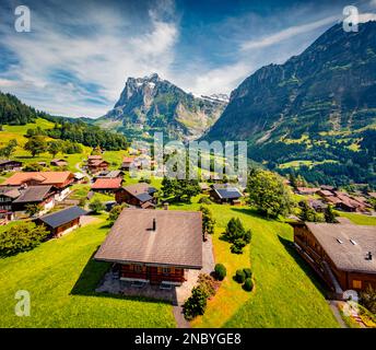 Splendida vista estiva dal drone volante del villaggio di Grindelwald. Sole di mattina scena di enormi vette montane nelle Alpi bernesi dell'Oberland, Svizzera, Euro Foto Stock