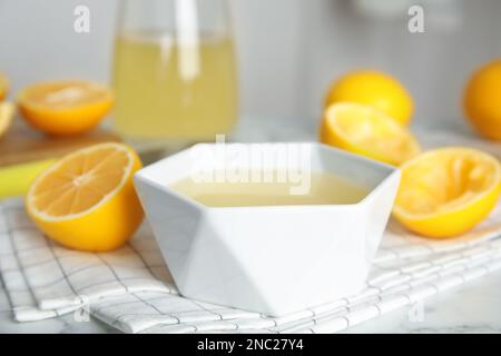 Succo di limone appena spremuto nel recipiente sul tavolo Foto Stock