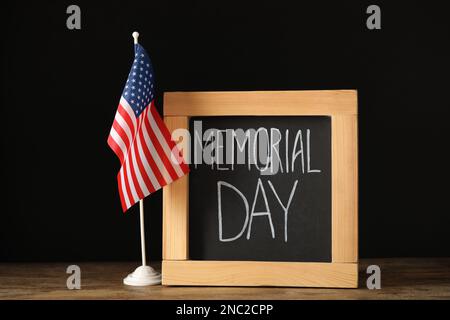 Lavagna con frase Memorial Day e bandiera americana su tavolo di legno Foto Stock