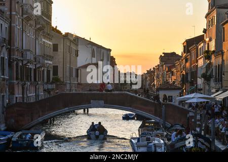 Ponte dei Ormesini sul canale del Rio della Misericordia nel sestiere di Cannaregio con la gente al tramonto, Venezia, Veneto, Italia Foto Stock