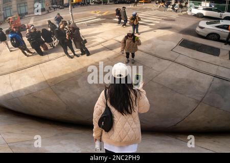 Una folla di visitatori si addossano alla più recente attrazione, la scultura a nuvola specchiata dell’artista Anish Kapoor, ancora senza nome, alla base di 56 Leonard Streets a Tribeca a New York, vista domenica 5 febbraio 2023. La scultura da 40 tonnellate è simile alla “Cloud Gate” di Kapoor a Chicago, ma in miniatura e progettata per apparire come se fosse schiacciata dall’edificio sopra di essa. (© Richard B. Levine) Foto Stock