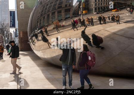 Una folla di visitatori si addossano alla più recente attrazione, la scultura a nuvola specchiata dell’artista Anish Kapoor, ancora senza nome, alla base di 56 Leonard Streets a Tribeca a New York, vista domenica 5 febbraio 2023. La scultura da 40 tonnellate è simile alla “Cloud Gate” di Kapoor a Chicago, ma in miniatura e progettata per apparire come se fosse schiacciata dall’edificio sopra di essa. (© Richard B. Levine) Foto Stock