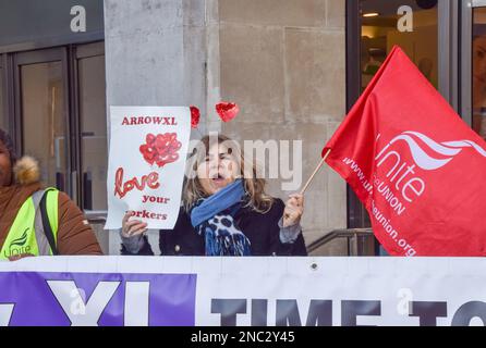 Londra, Regno Unito. 14th Feb, 2023. Durante la dimostrazione, un protester con fascia per capelli a cuore rosso ha una bandiera Unite e un cartello con la scritta "Arrow XL, Love Your Workers". Unisci i membri sindacali fase a San Valentino di protesta al di fuori Marks & Spencer su Oxford St over consegna società Arrow XL, parte del gruppo Logistics Holdings Ltd, che è stato accusato di pagare salari molto bassi ai lavoratori. United sta chiedendo a rivenditori come Marks & Spencer, che lavorano con la società logistica, di esercitare pressione sul proprio fornitore. Credit: SOPA Images Limited/Alamy Live News Foto Stock