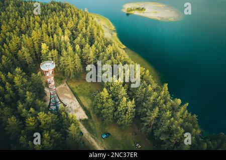 La torre dell'orologio di Labanoras dalla prospettiva aerea con il lago sullo sfondo. Immagine quadrata di una campagna della Lituania. Parco regionale di Labanoras Foto Stock