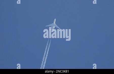 Un'inquadratura ad angolo basso di un jet plane con contrasti contro un cielo blu chiaro Foto Stock