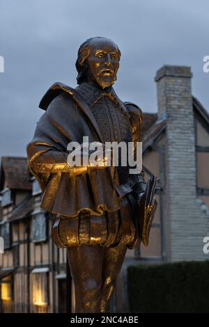 Statua in bronzo del Bard William Shakespeare illuminata di notte e situata accanto al suo luogo di nascita in Henley Street a Stratford-upon-Avon, Regno Unito Foto Stock