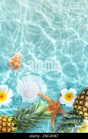 Ananas giallo, conchiglie e fiori bianchi su sfondo blu. Concetto esotico. Foto Stock