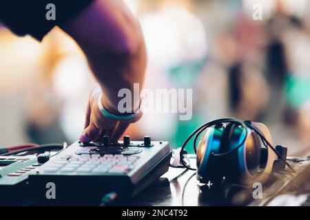 DJ suona musica durante il festival estivo. Disco jockey utilizzando il dispositivo di controllo midi in concerto Foto Stock