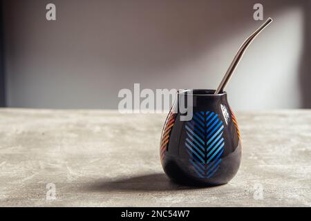 tazza di yerba mate in ceramica piuttosto lucida, con design a foglia blu e paglia di metallo bombarbilla Foto Stock