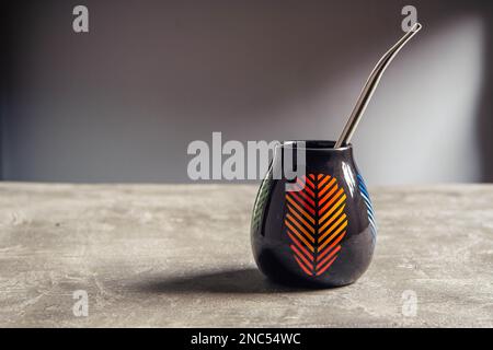 tazza di yerba mate in ceramica piuttosto lucida, con design a foglia arancione e paglia di metallo bombarbilla Foto Stock