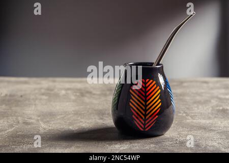 tazza di yerba mate in ceramica piuttosto lucida, con design a foglia arancione e paglia di metallo bombarbilla Foto Stock