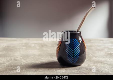 tazza di yerba mate in ceramica piuttosto lucida, con design a foglia blu e paglia di metallo bombarbilla Foto Stock