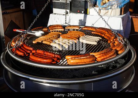 salsicce arrostire su un grande grill Foto Stock