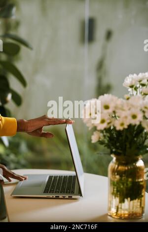 Mani di una donna che chiude il notebook dopo un dat produttivo in ufficio a casa Foto Stock