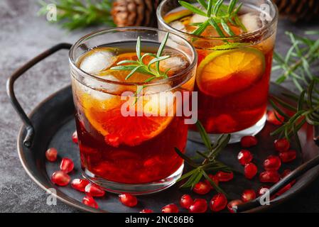 Cocktail di melograno decorato con lime, rosmarino e ghiaccio, bevanda fredda Foto Stock