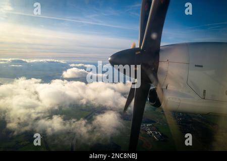 la grande elica di un aereo a elica che vola sopra le nuvole Foto Stock