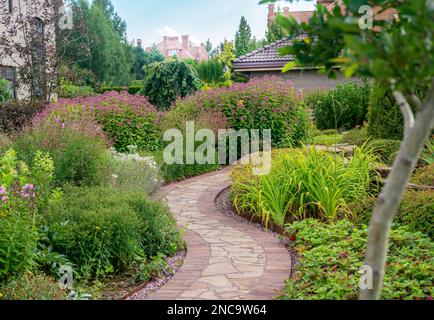 Incredibile giardinaggio in uno dei palazzi (dacha) in prospero villaggio con sanguidosrba, echinacea, e percorso villaggio belga (così chiamato) a Mosca Foto Stock