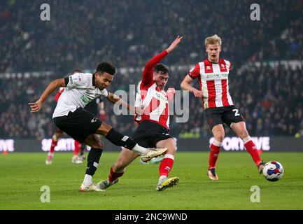 Il Korey Smith (a sinistra) della contea di Derby tenta di sparare in gol durante la partita della Sky Bet League One al Pride Park Stadium, Derby. Data immagine: Martedì 14 febbraio 2023. Foto Stock