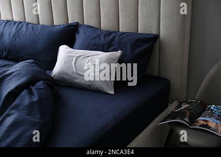 Letto con eleganti lenzuola di seta in camera Foto stock - Alamy