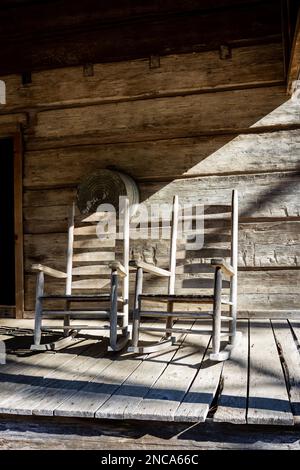 Un primo piano di sedie a dondolo su un portico frontale in legno della storica cabina in legno dell'epoca della guerra civile nei giardini Callaway in Georgia Foto Stock