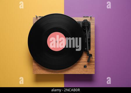 Giradischi moderno con dischi in vinile su sfondo a colori, vista dall'alto Foto Stock