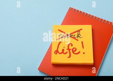 Notebook, note adesive su sfondo azzurro con spazio per il testo, vista dall'alto. Concetto di equilibrio tra vita e lavoro Foto Stock