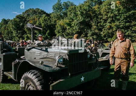 Una jeep dell'epoca della seconda guerra mondiale con un machinegun montato circondato da truppe in un campo tenda durante una rievocazione presso l'American Heritage Museum. L'immagine era capt Foto Stock