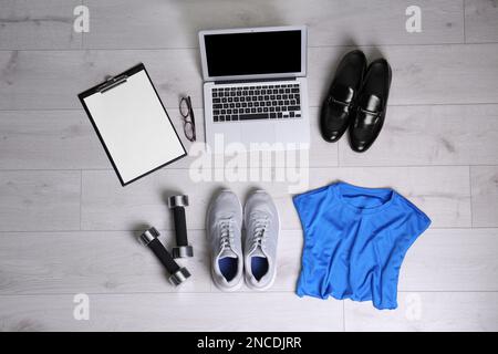 Posa piatta composizione di articoli business con accessori sportivi su fondo in legno bianco. Concetto di equilibrio tra vita e lavoro Foto Stock