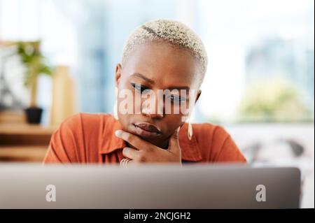 La strada verso il successo è sempre in costruzione. una giovane donna d'affari che guarda premurosa mentre lavora su un notebook in ufficio. Foto Stock