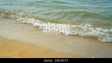 Onde di mare che fanno schiume bianche schiantarsi sulla riva. Concetto di sfondo della natura. Foto Stock