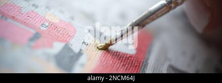 La persona tiene il pennello e disegna l'immagine con le pitture dai numeri Foto Stock