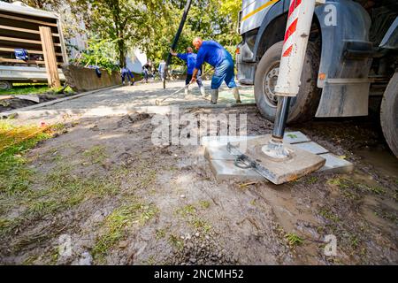 Lo stabilizzatore laterale esteso fornisce supporto e stabilità al dumper miscelatore per versare calcestruzzo nel cantiere. Foto Stock